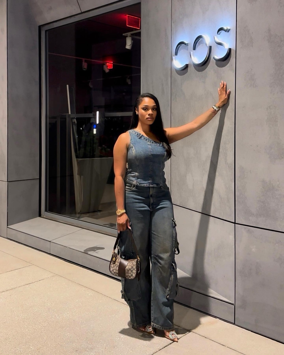 Vanessa in a denim outfit posing at the COS store front