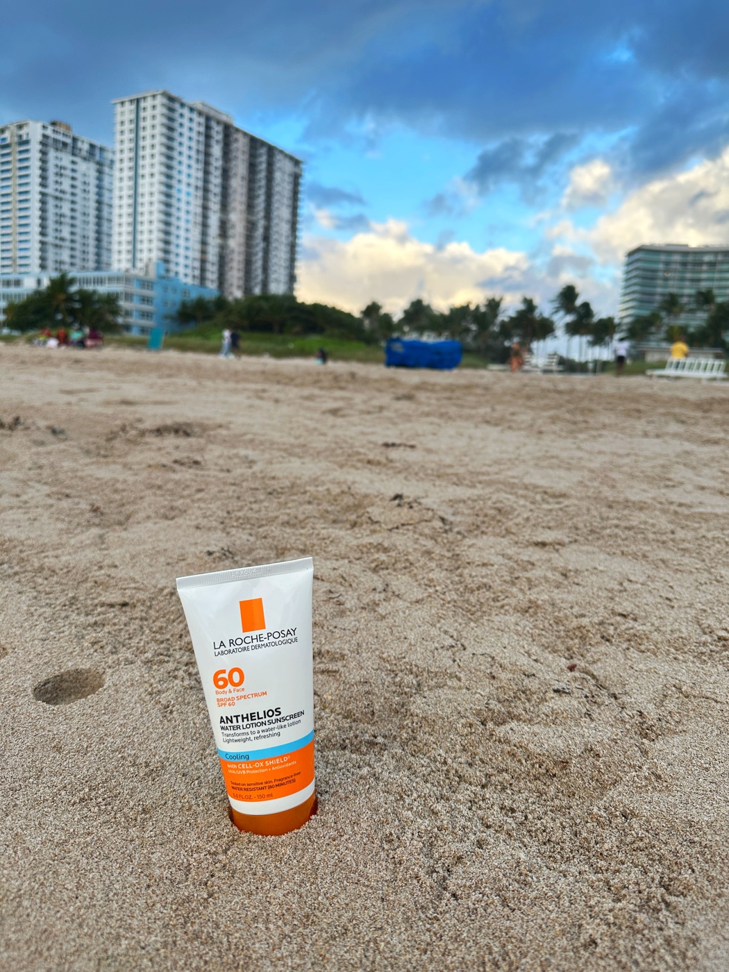 La Roche-Posay Anthelios sunscreen standing in the sand on the beach